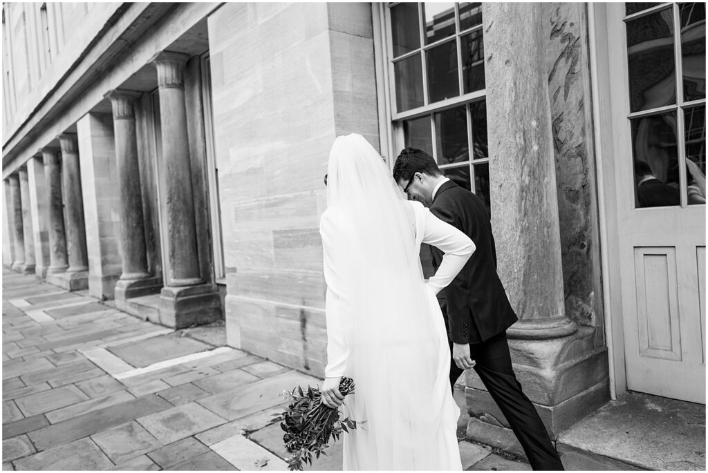 A bride and groom walk down a sidewalk towards Royal Boucherie.