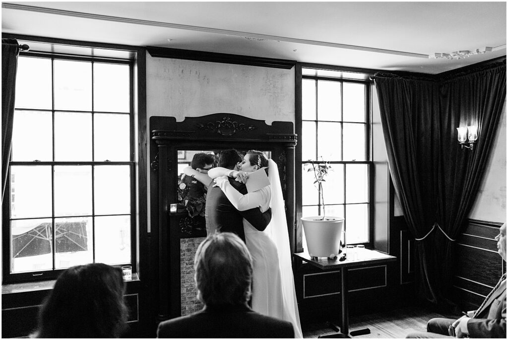 A bride and groom hug during a wedding ceremony in a Philadelphia restaurants.