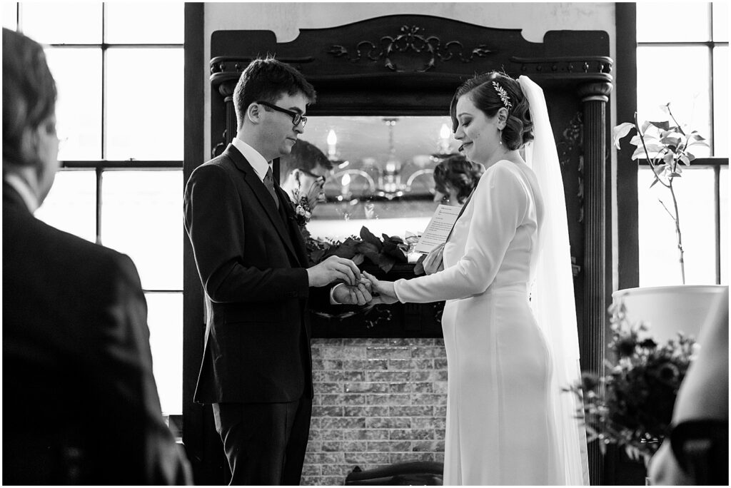 A groom puts a wedding ring on a bride's finger at a Royal Boucherie wedding.