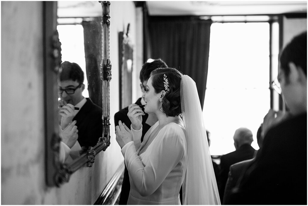 A bride applies lipstick using a mirror in the dining room of Royal Boucherie.