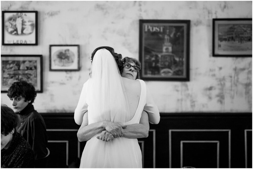 A bride hugs a family member.