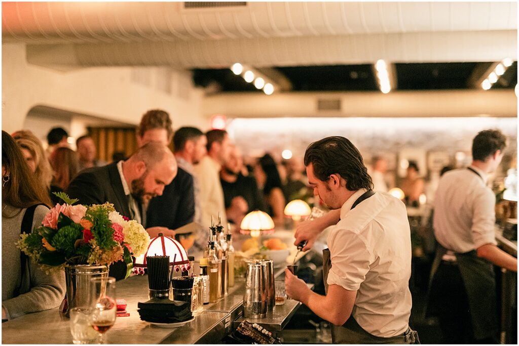 A bartender pours drinks for wedding guests at Giuseppe & Sons.