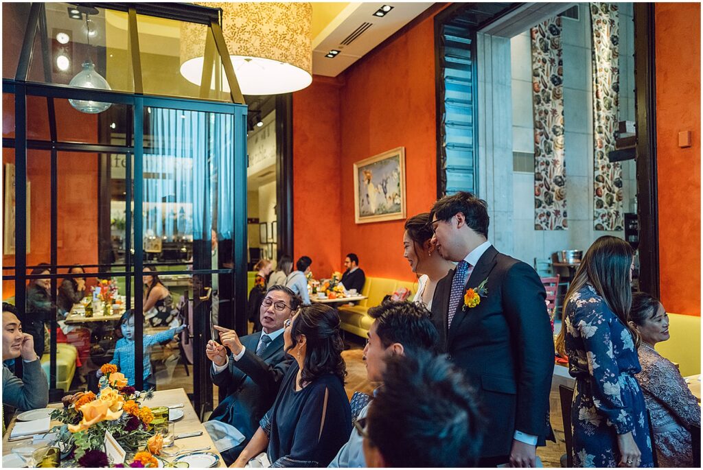 Wedding guests walk around a colorful dining room.