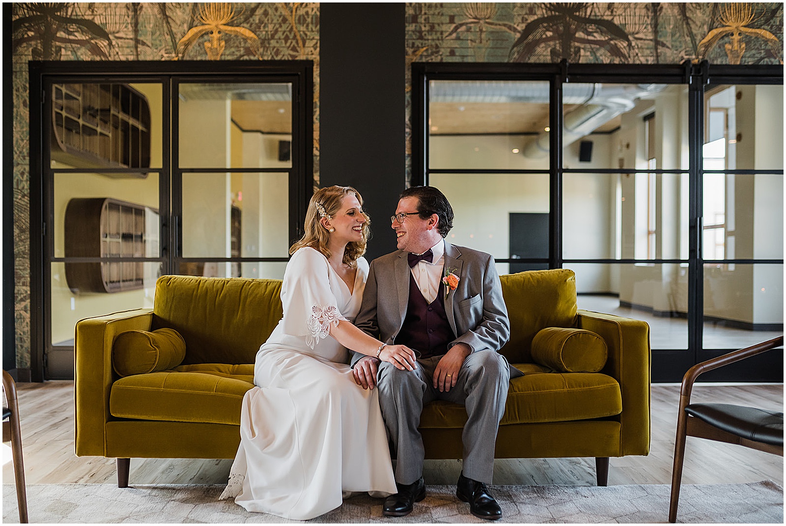 A bride and groom cuddle on a couch inside Lark, a Philadelphia restaurant wedding venue.