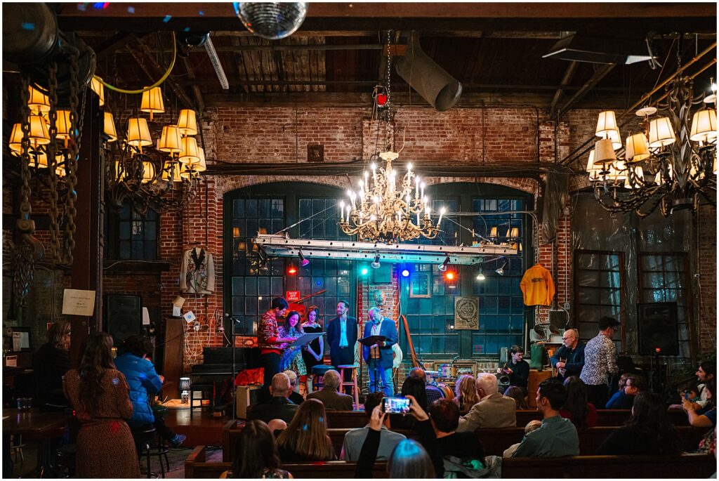 A bride and groom stand on stage at the Black Squirrel Club.