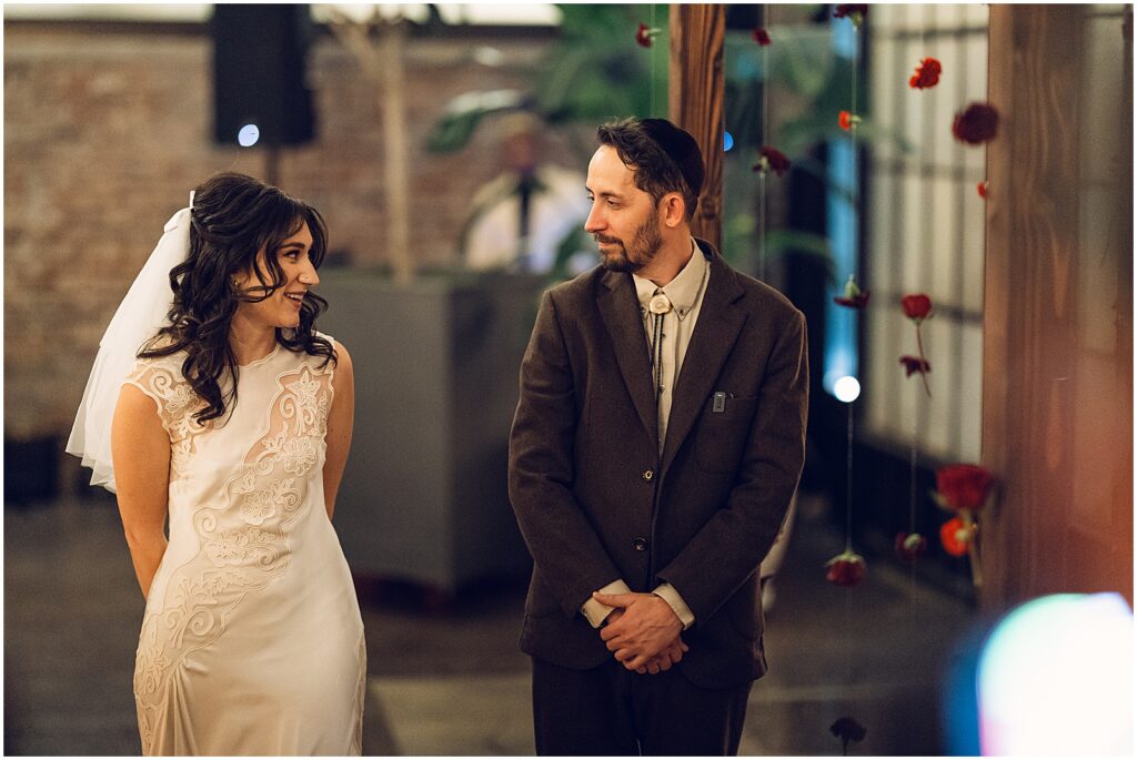 A bride and groom smile at each other during their Philadelphia wedding ceremony.