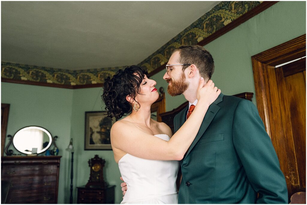 A bride and groom embrace in a getting ready suite.