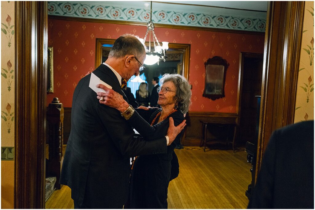 Family members hug in a historic wedding venue.