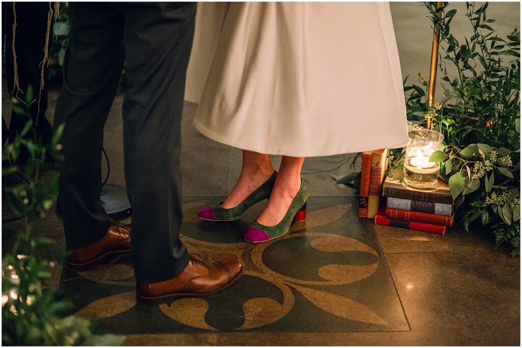 A candle sits on a stack of old books beside a chuppah at a Knowles Mansion wedding.