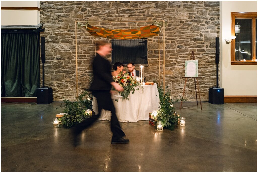 Someone runs past a sweetheart table.