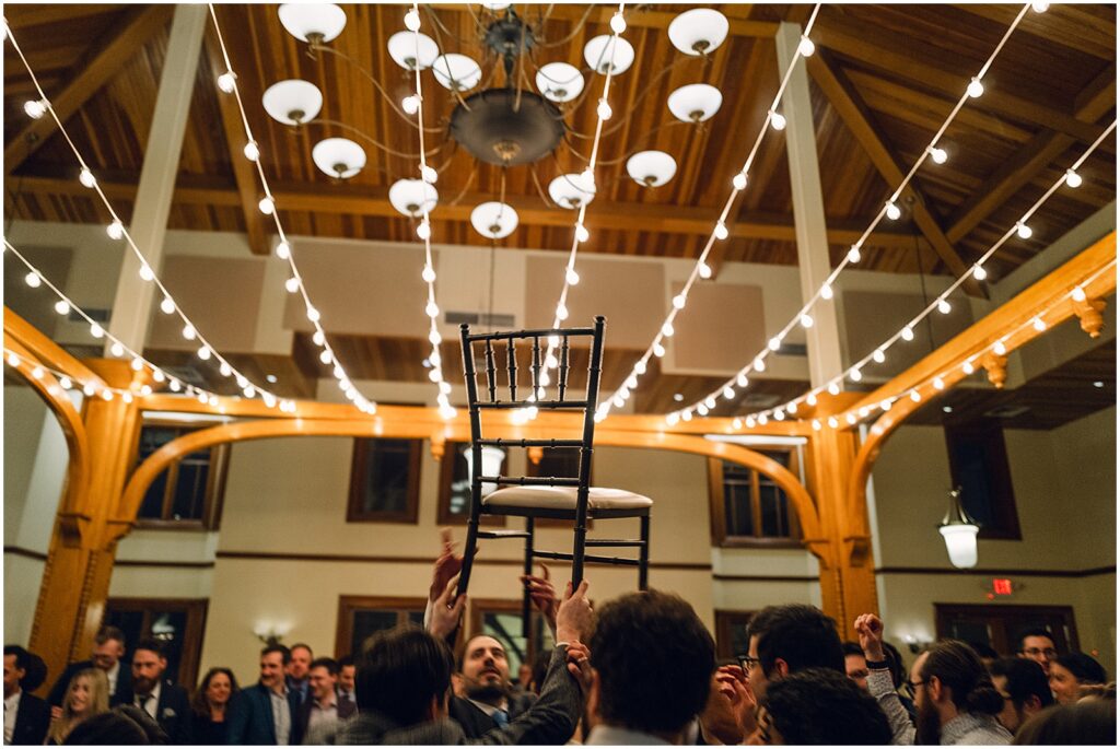Guests carry a chair across a dance floor.
