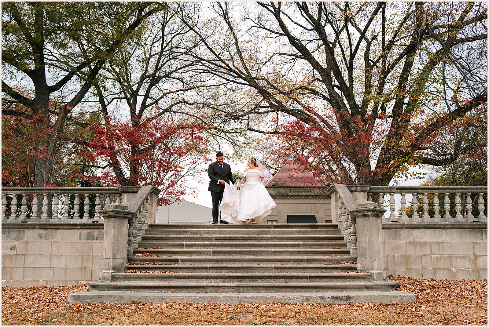 A bride and groom stand an a staircase outdoors at a Curtis Arboretum wedding.