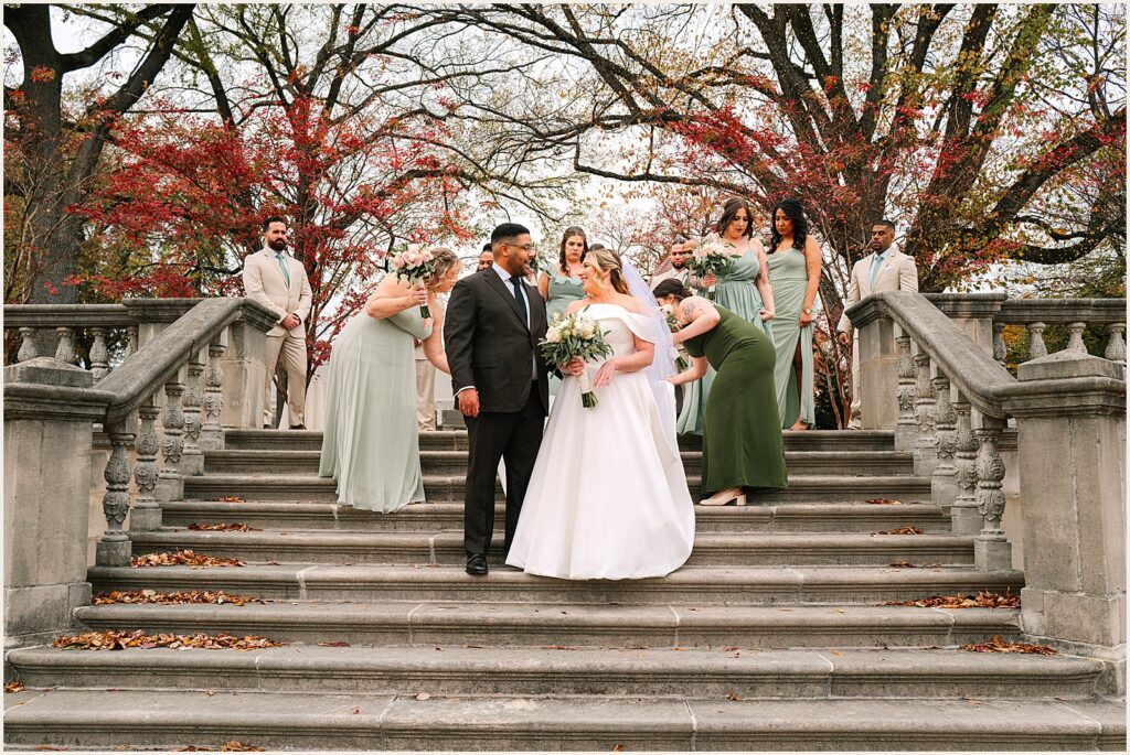 A bride and groom walk down a staircase in front of their wedding party at a Curtis Arboretum wedding.