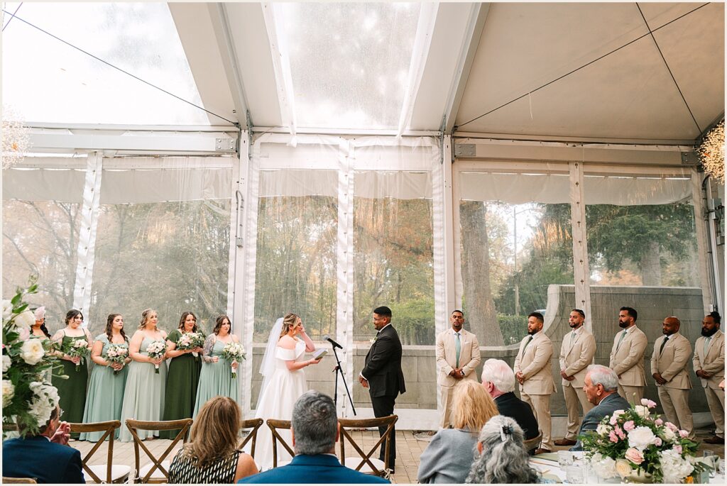 A bride reads vows into a microphone.