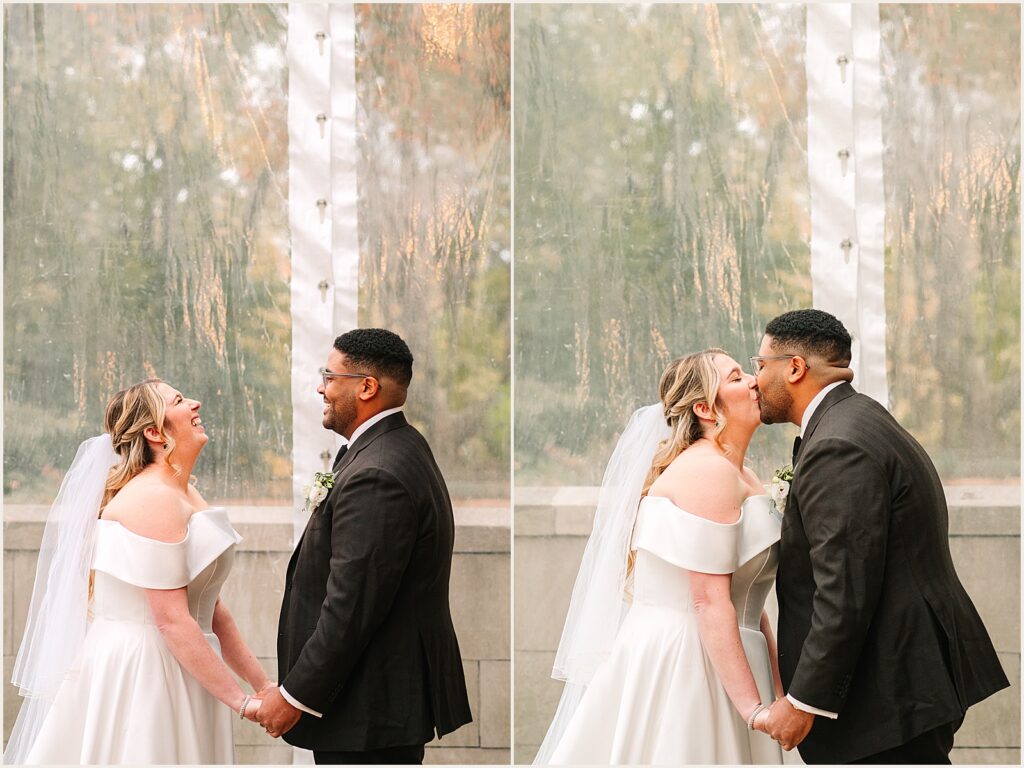 A bride and groom share their first kiss at a ceremony inside a wedding tent.