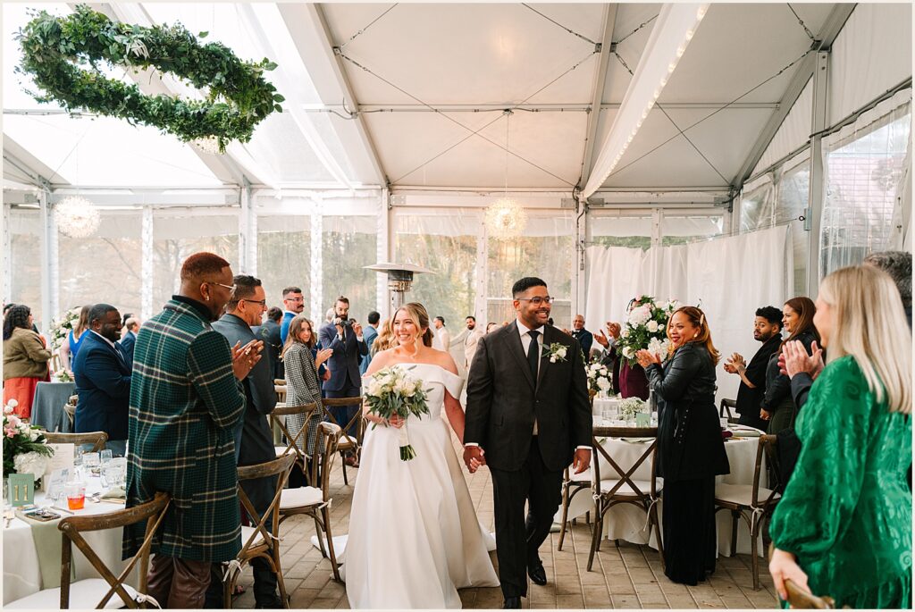A bride and groom smile during their ceremony recessional.