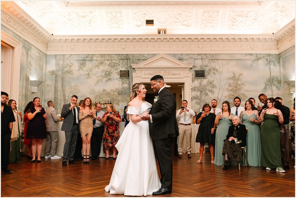 A bride and groom share their first dance in the hall at a Curtis Arboretum wedding.