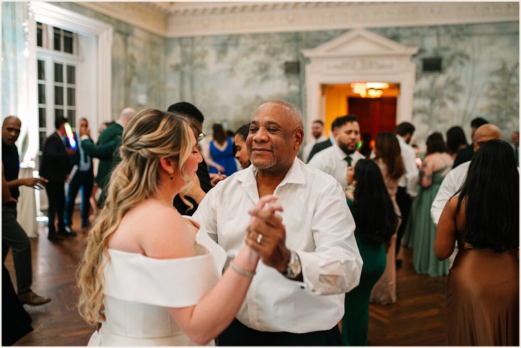 A bride dances with her father-in-law.