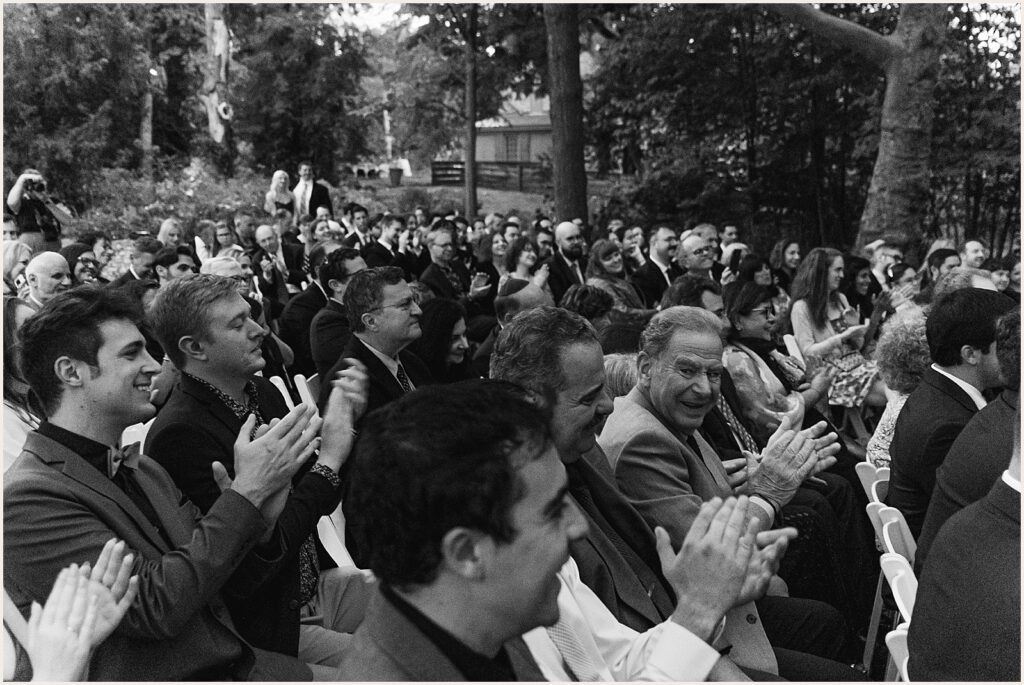 Wedding guests clap at a ceremony.