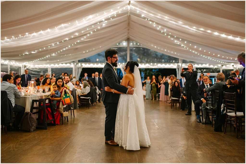 A bride and groom have their first dance in a tent at Bartram's Garden.