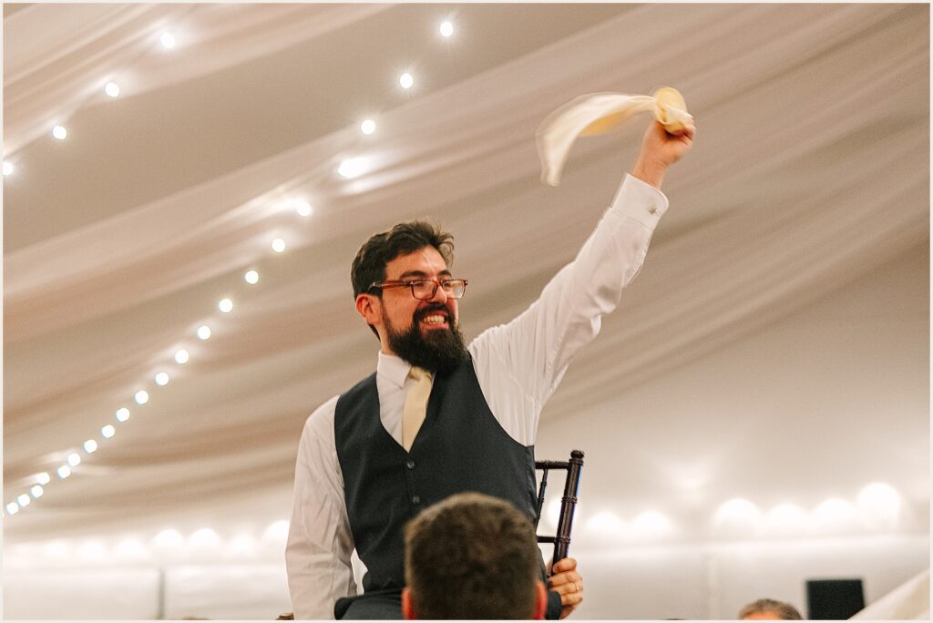 A groom waves a handkerchief during the hora.