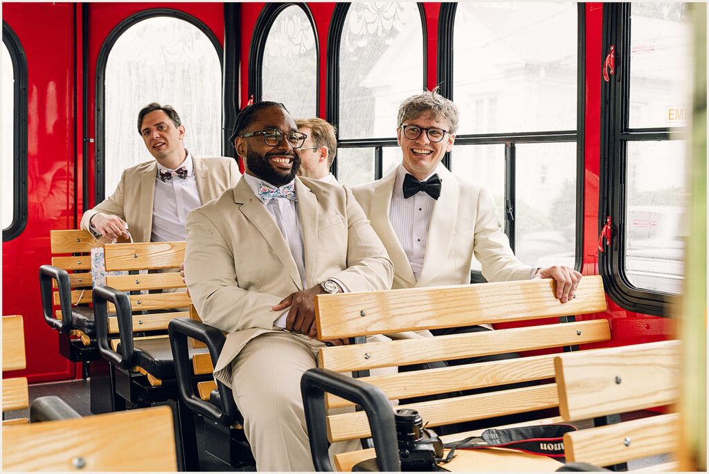 A groom rides a trolley with his groomsmen.