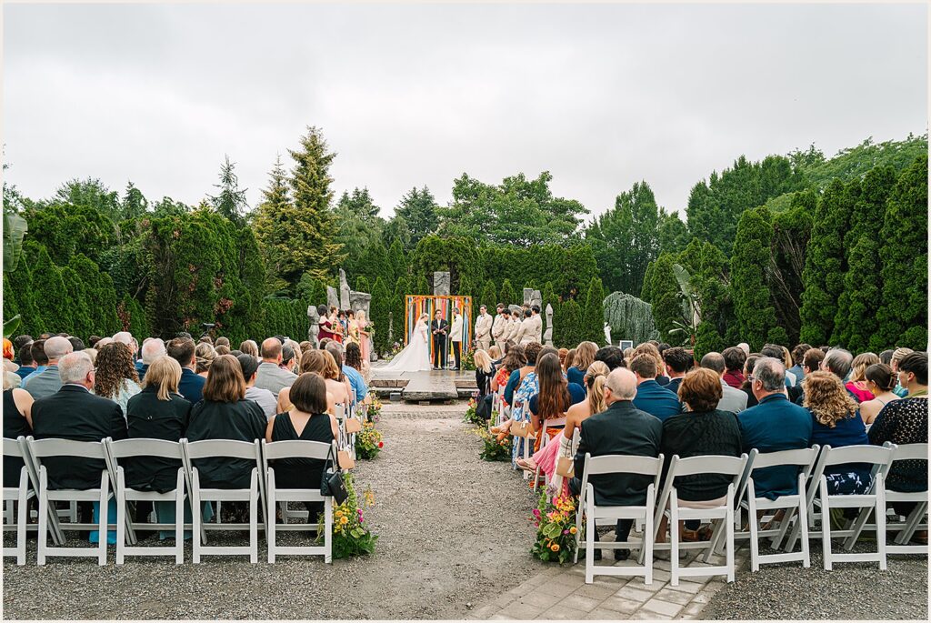 Wedding guests watch a ceremony at a Grounds for Sculpture wedding.
