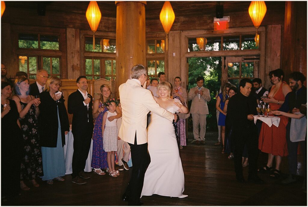 Wedding guests watch a bride and groom's first dance.