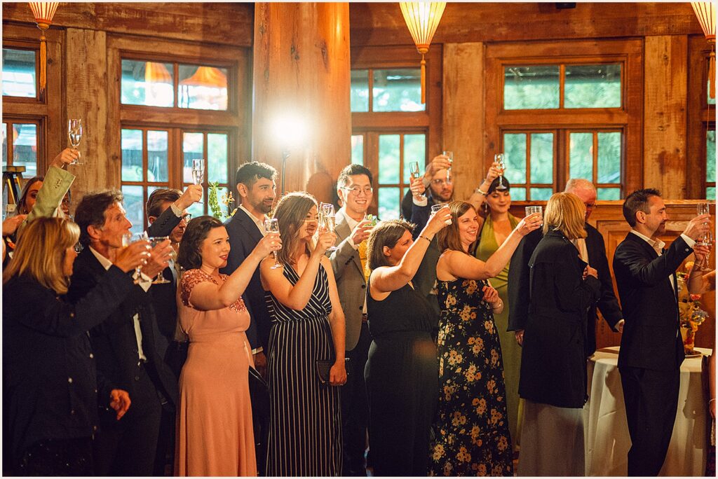 Wedding guests raise their glasses for a toast.
