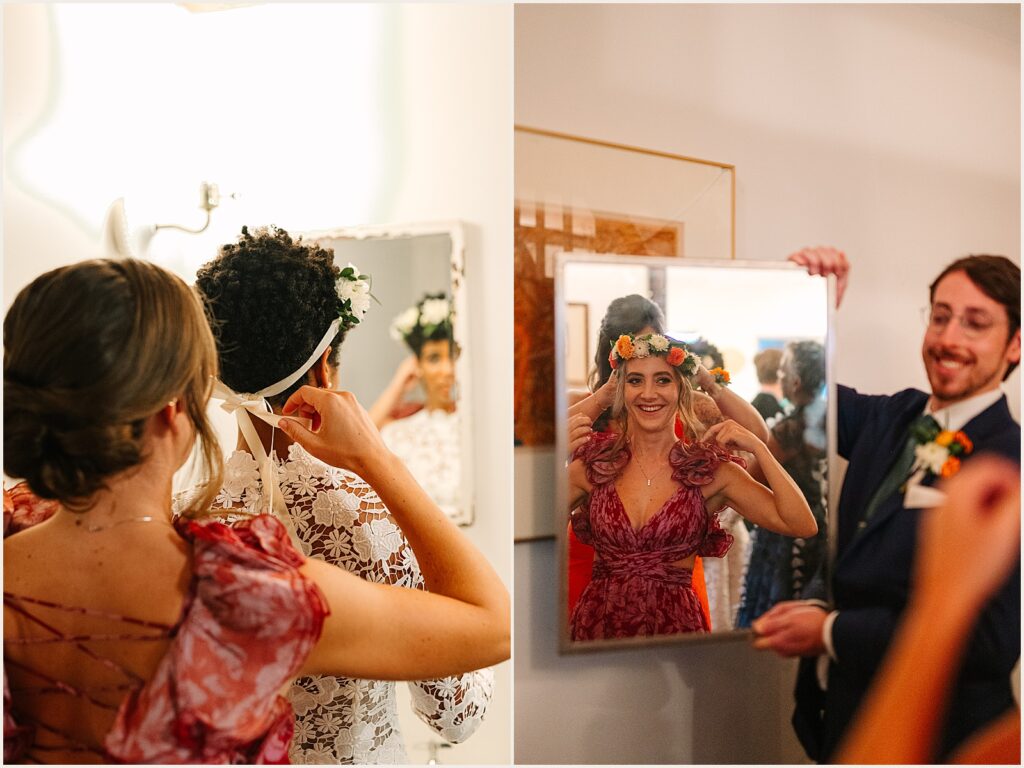 A bridesmaid helps a bride put on a flower crown.