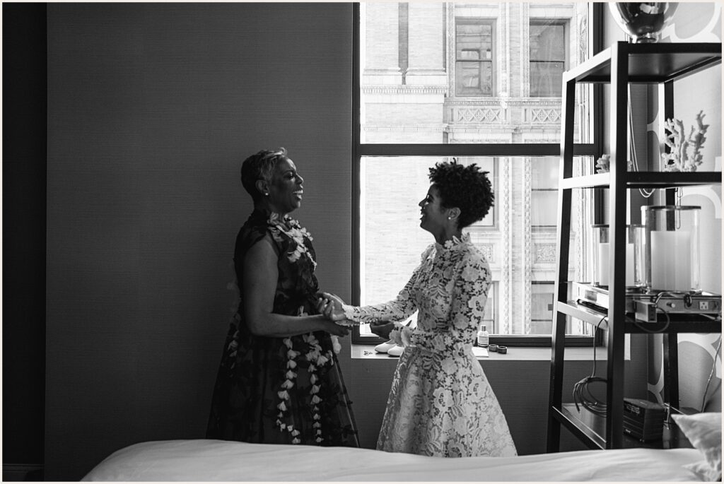 A bride's mother helps her put on a bracelet.