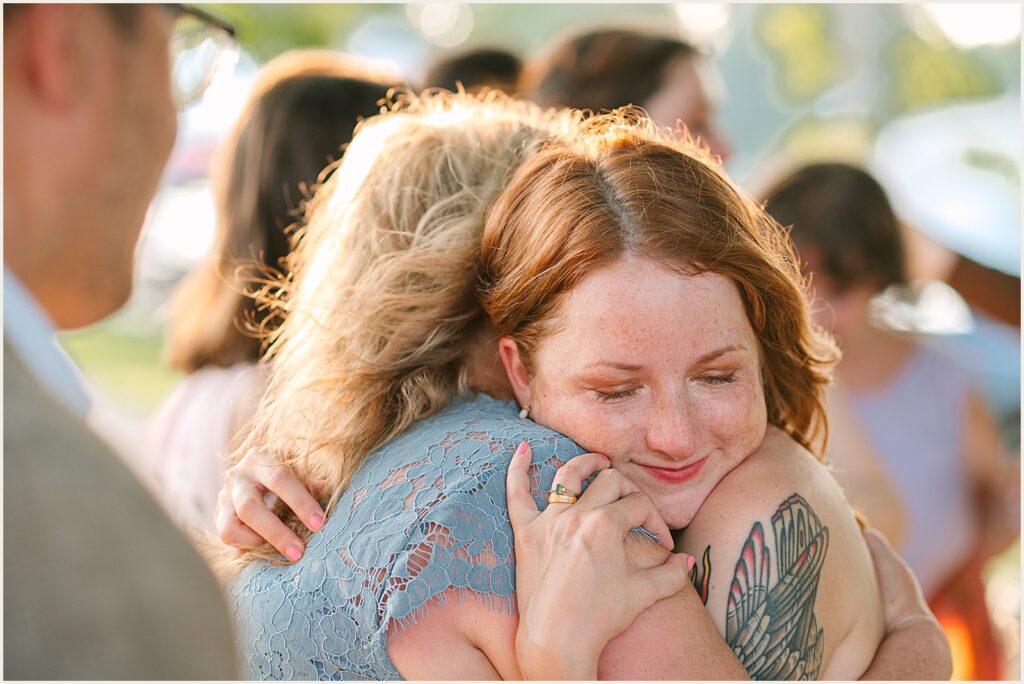 A bride hugs a family member.