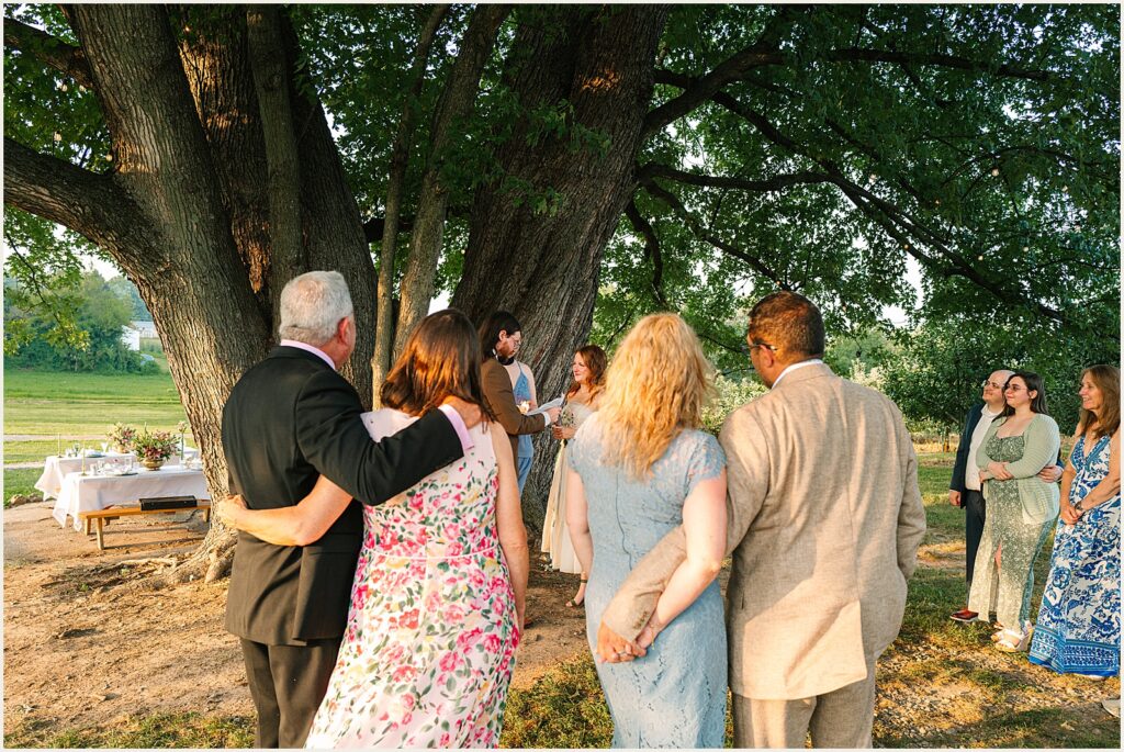 Guests snuggle and watch a wedding ceremony.