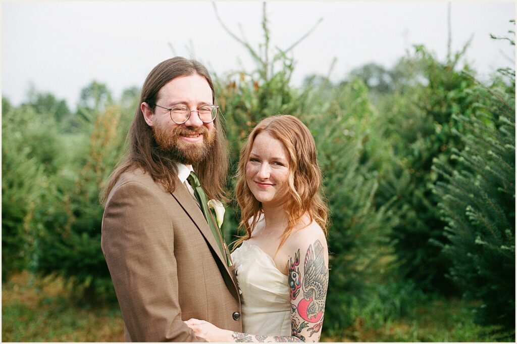 A bride and groom pose in vintage wedding attire.