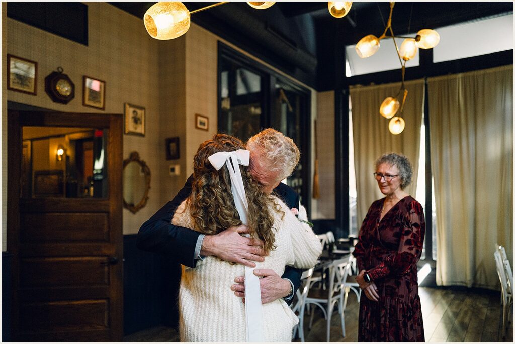 A bride hugs her father.