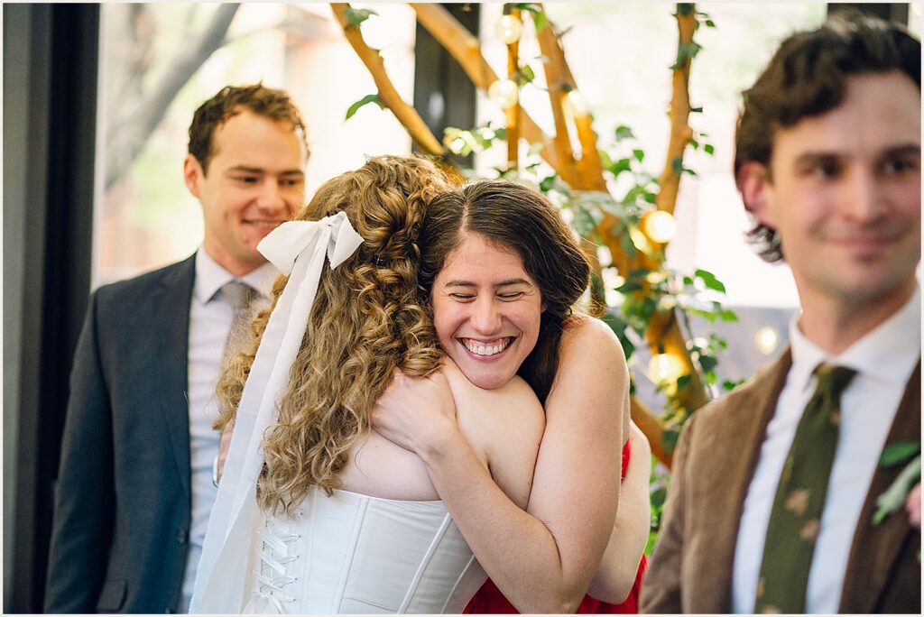 A bride hugs a wedding guest.