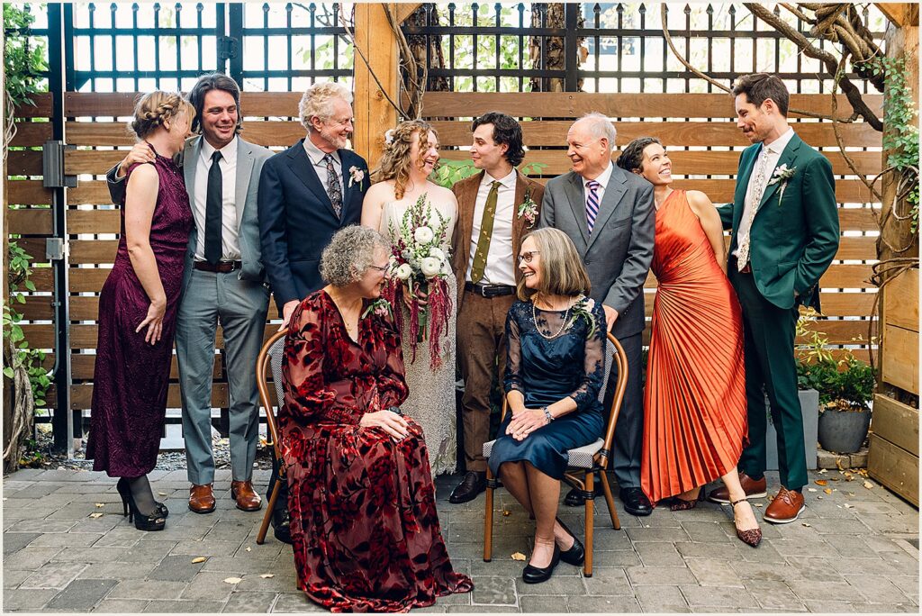 A bride and groom pose for a portrait with family members.