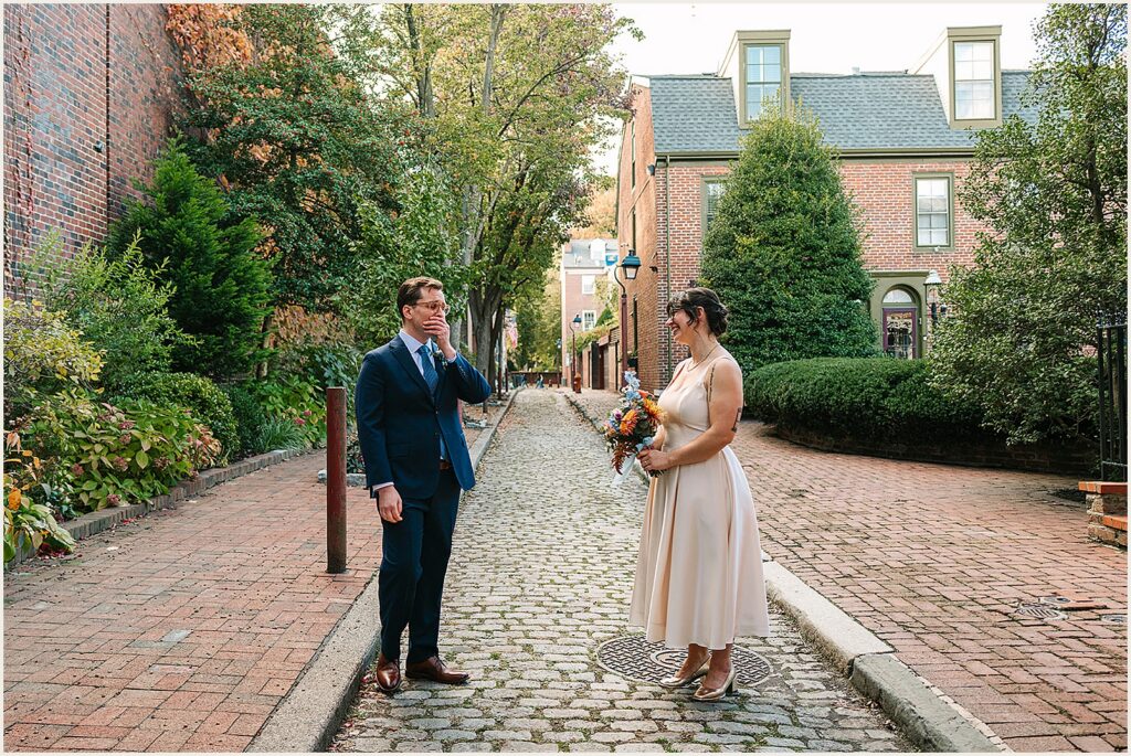 A groom covers his mouth during a first look in Old City Philadelphia.