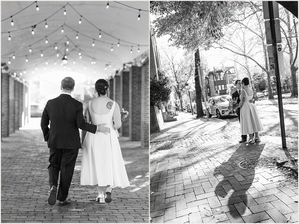 A groom puts his arm around a bride on a Philadelphia sidewalk.