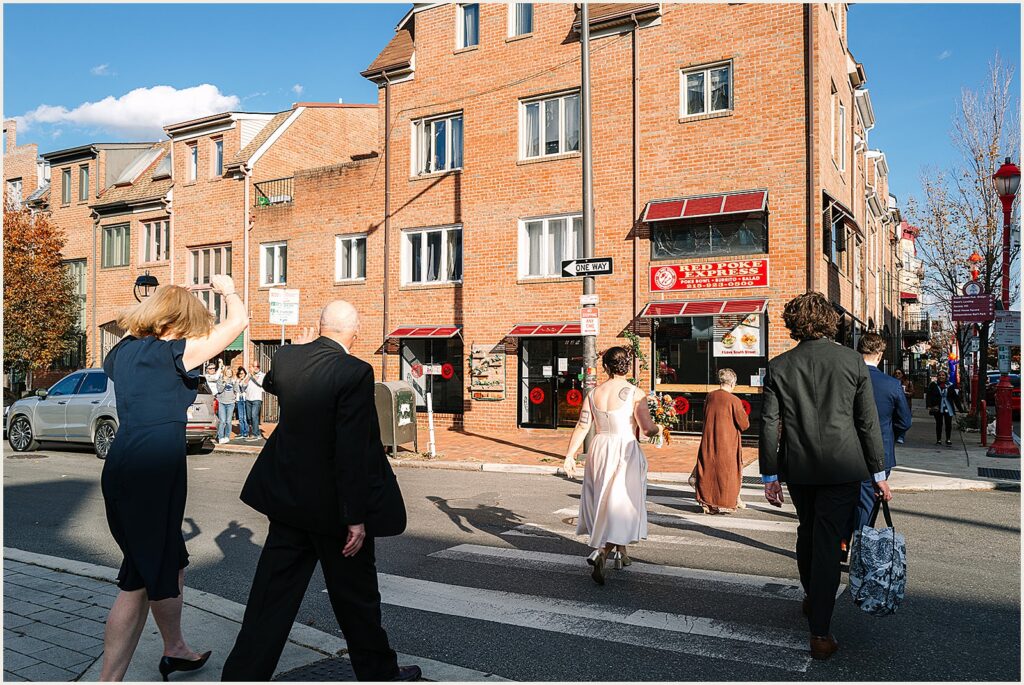 A bride and groom cross a Philadelphia street.