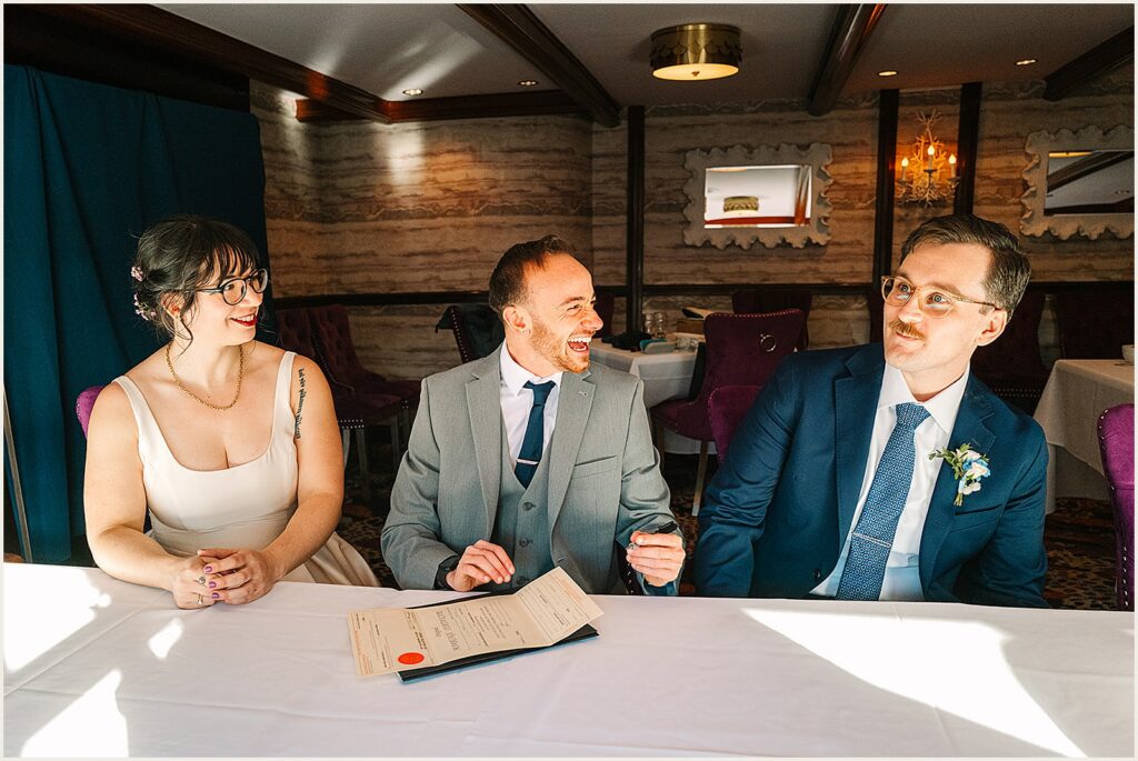 A bride and groom sign their marriage license.