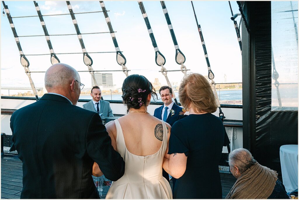 A bride's parents walk her up the aisle at a Moshulu wedding.