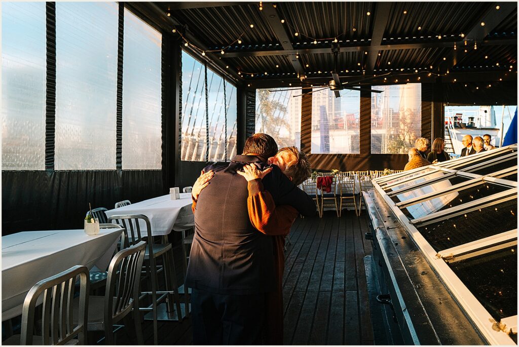 Two people embrace inside a restaurant.