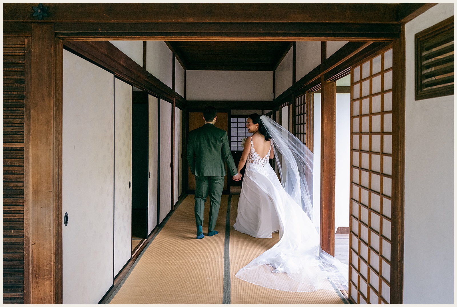 A bride and groom walk down a hallway at Shofuso Japanese Garden.
