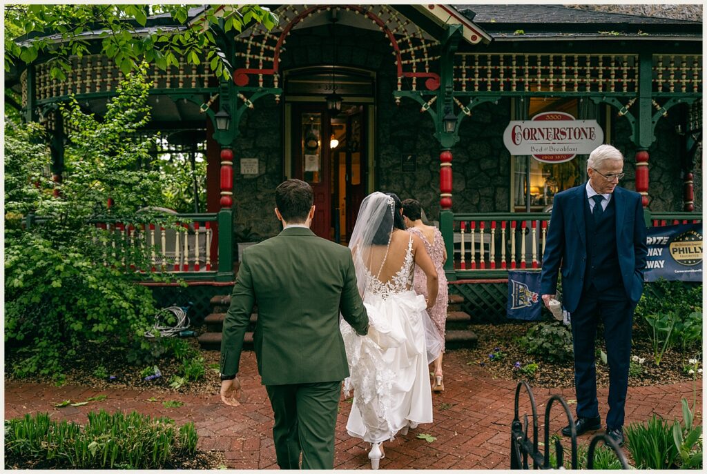 A bride and groom walk towards a Philadelphia bed and breakfast.