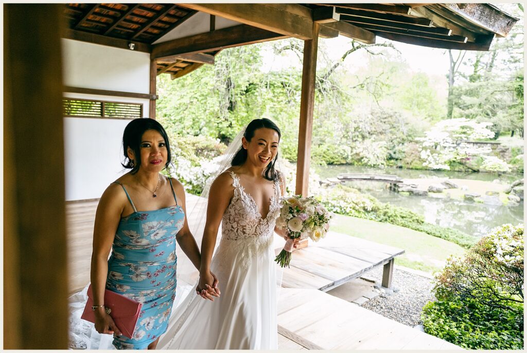 A bride holds her sister's hand.