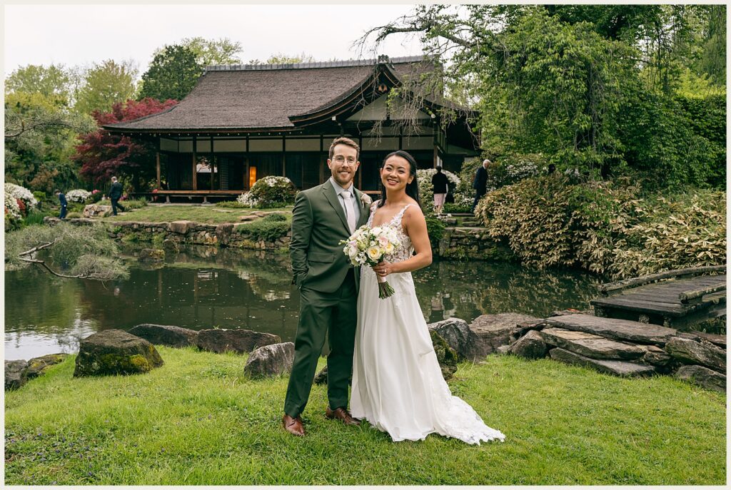 A bride and groom pose in front of the house at Shofuso Japanese Garden.
