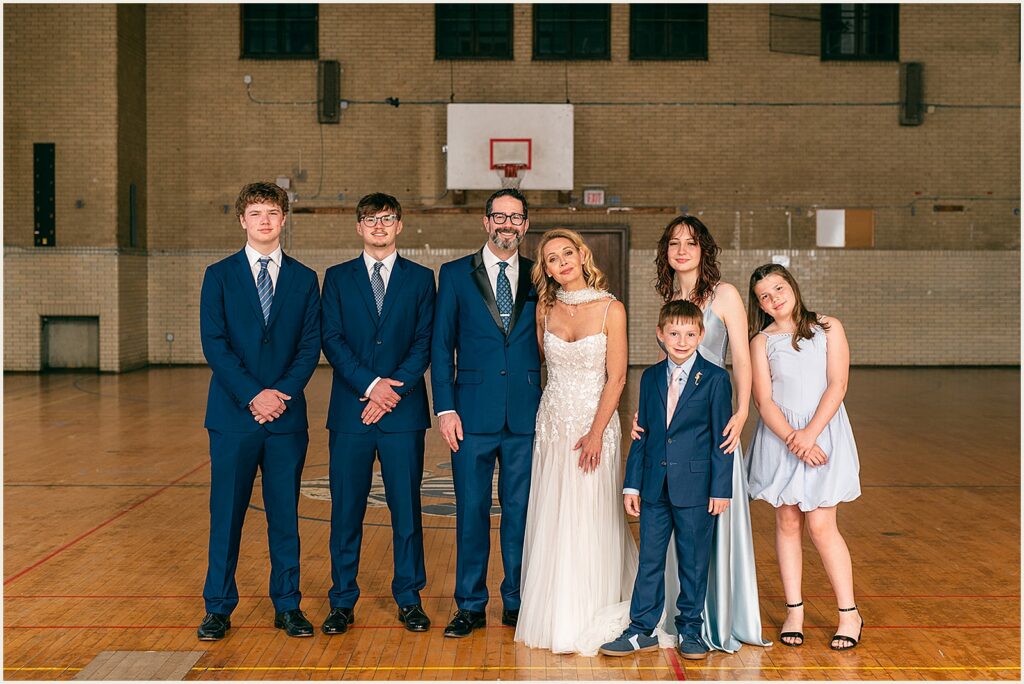 A bride and groom pose with their children.