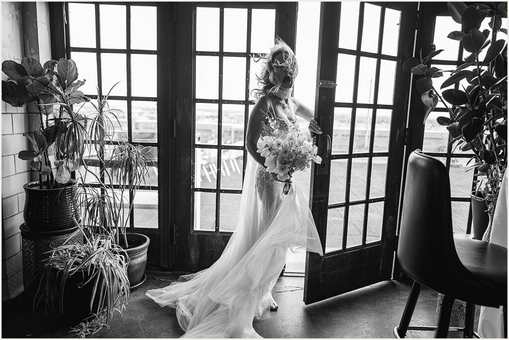 A bride laughs as the wind blows her hair across her face.
