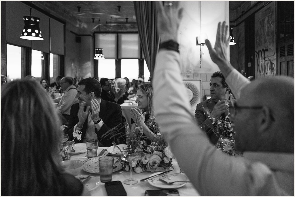 Wedding guests react to a speech.